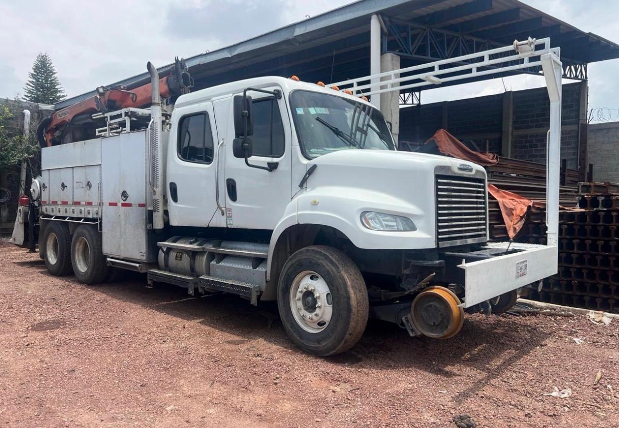 Camión torton con grúa articulada para carga de materiales ferroviarios
